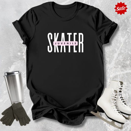 Black t-shirt with 'SKATER' and 'juvenile' text, surrounded by ice skates and a tumbler on a textured gray background.