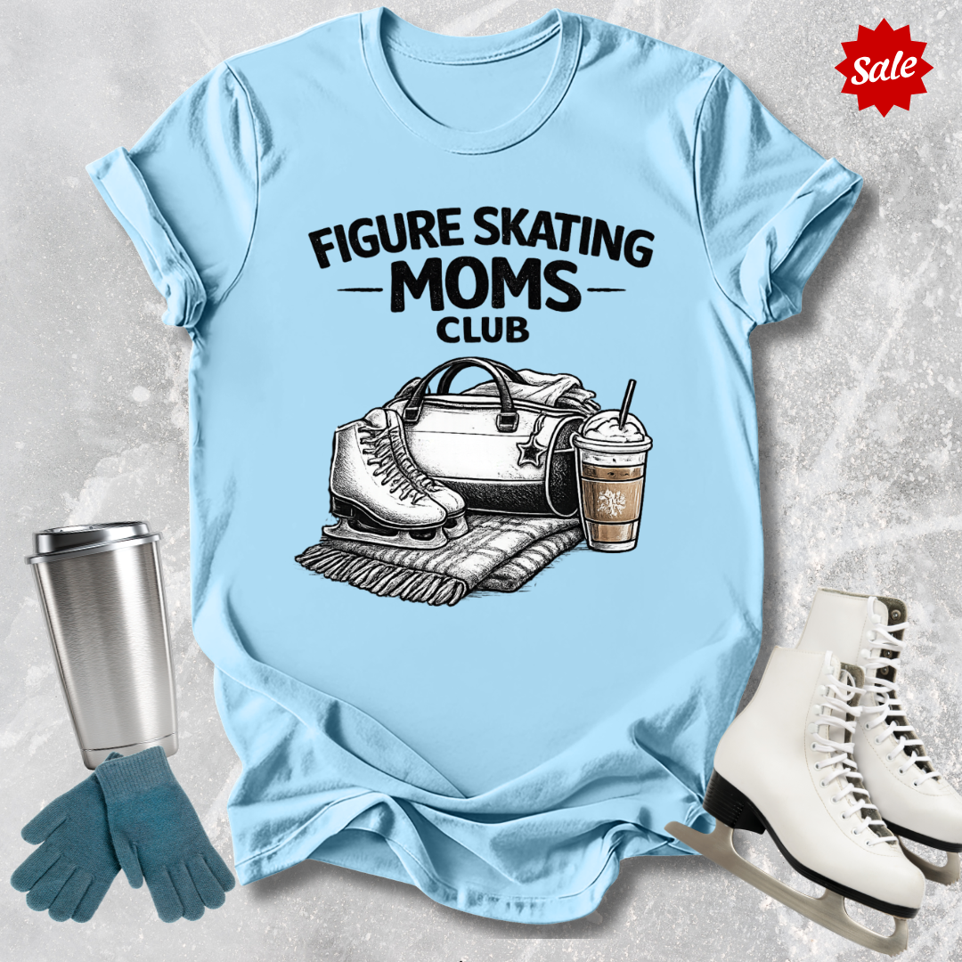 Light blue t-shirt with 'Figure Skating Moms Club' design, surrounded by ice skates, gloves, and a cup on a textured surface.