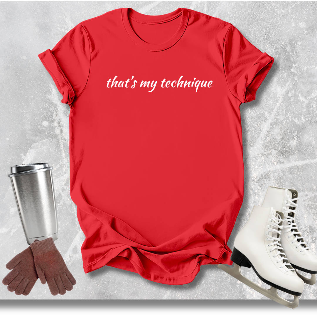 Red t-shirt with 'that's my technique' text, white skates, silver cup, and brown gloves on a textured gray background