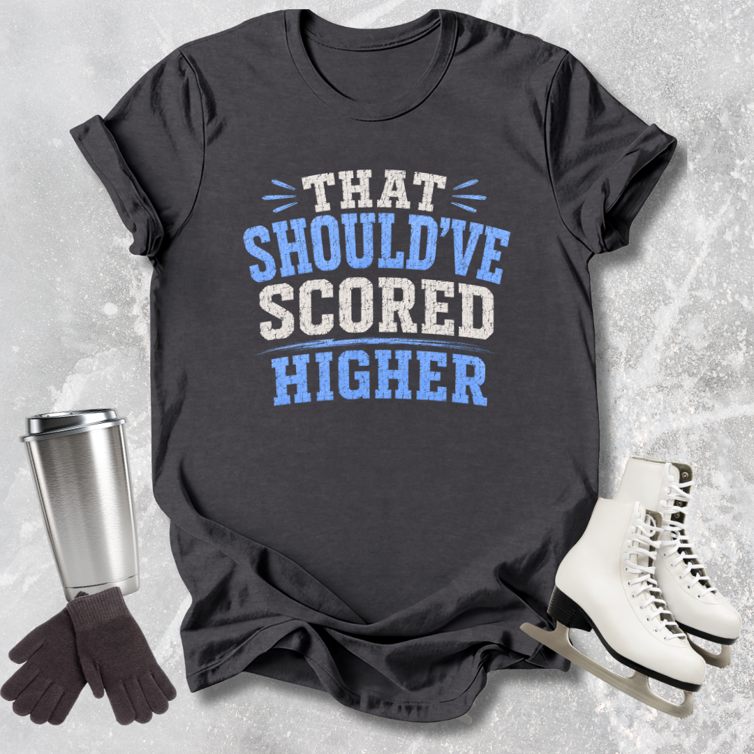 Black t-shirt with humorous text, next to a silver tumbler, black gloves, and white skates on a textured surface.