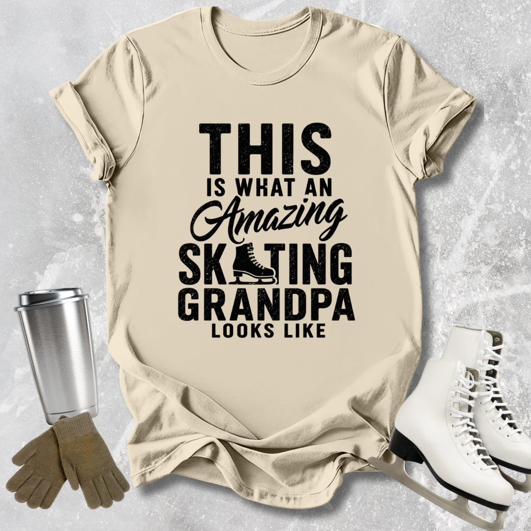 Beige t-shirt with text 'This is what an amazing skating grandpa looks like' on a textured surface with ice skates and a tumbler.