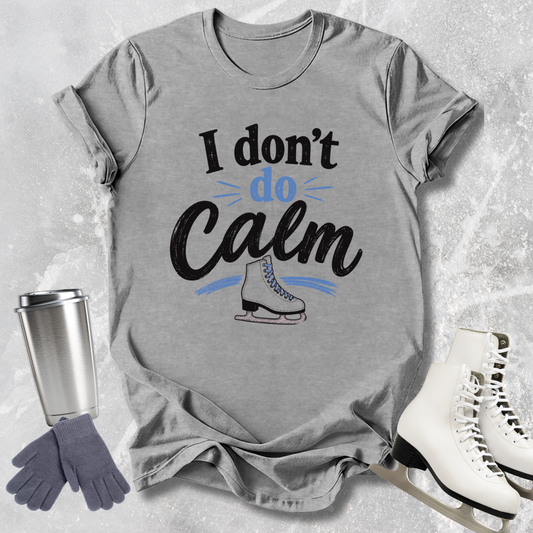 Gray t-shirt with 'I don't do Calm' text, ice skates, gloves, and skates on a textured gray background