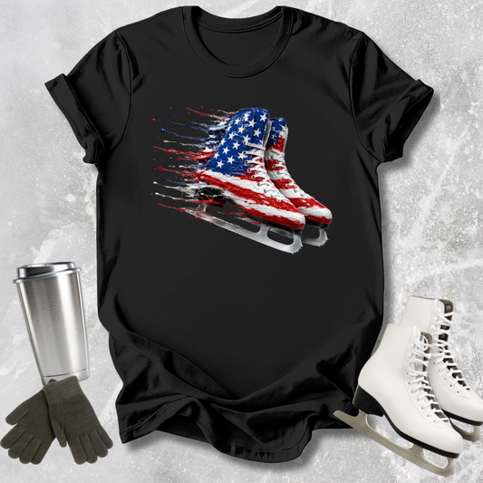 Black t-shirt with American flag ice skate design, placed on a textured surface with ice skates and gloves.