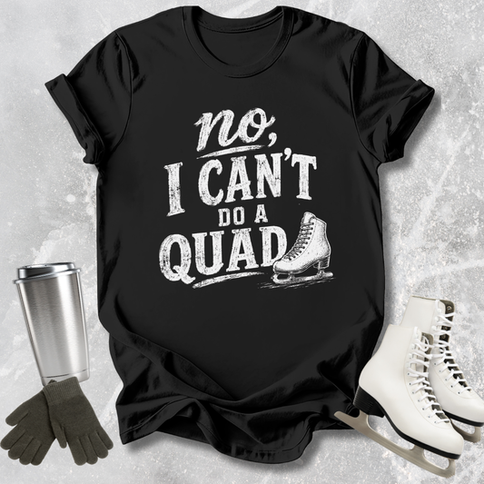 Black t-shirt with 'no, I can't do a quad' text and ice skate graphic on a textured gray background.