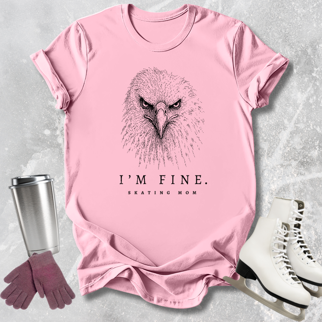 Pink t-shirt with an eagle graphic and text, placed on a textured surface with a tumbler, gloves, and skates.