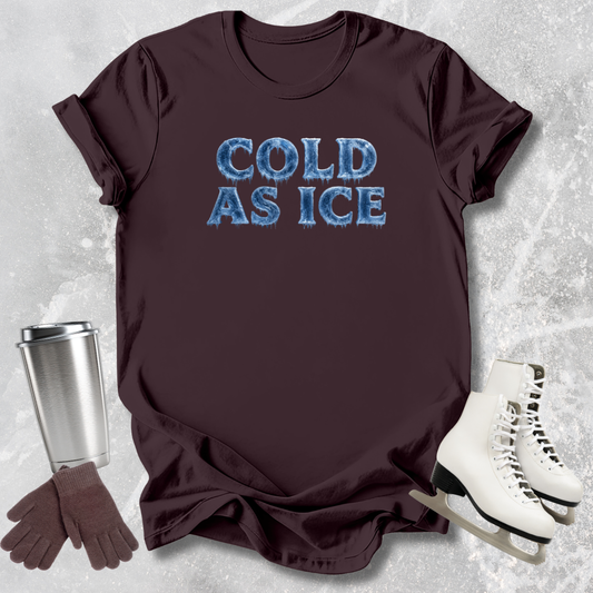 Brown t-shirt with 'COLD AS ICE' text, silver tumbler, brown gloves, and white skates on a textured gray background