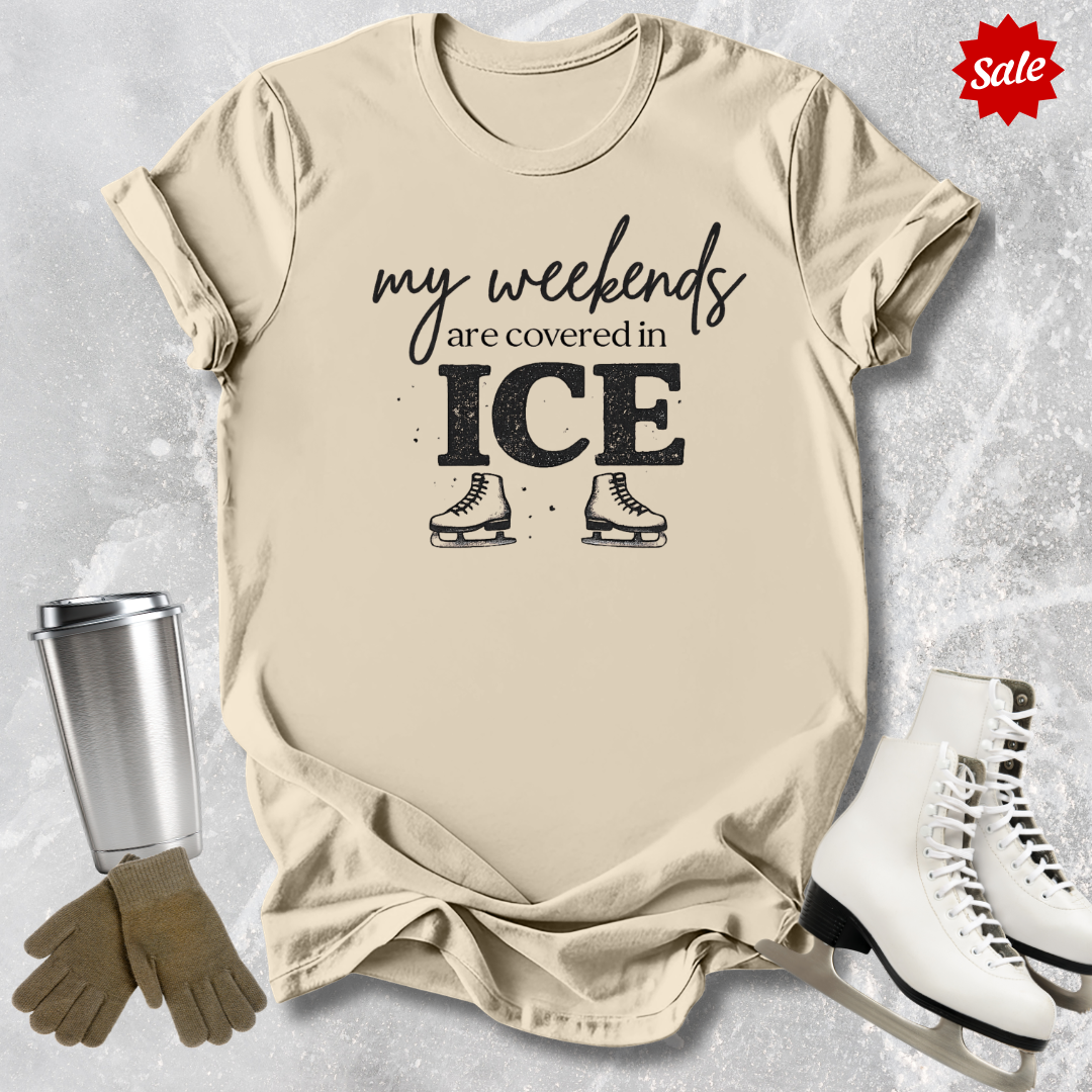 Beige t-shirt with 'my weekends are covered in ICE' text, ice skates, silver tumbler, and white ice skates on a textured gray background.