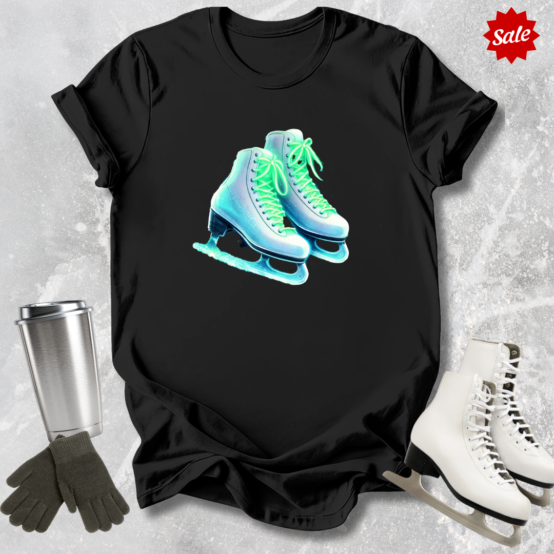 Black t-shirt with neon ice skate design  for figure skaters, silver tumbler, and white skates on a textured gray background