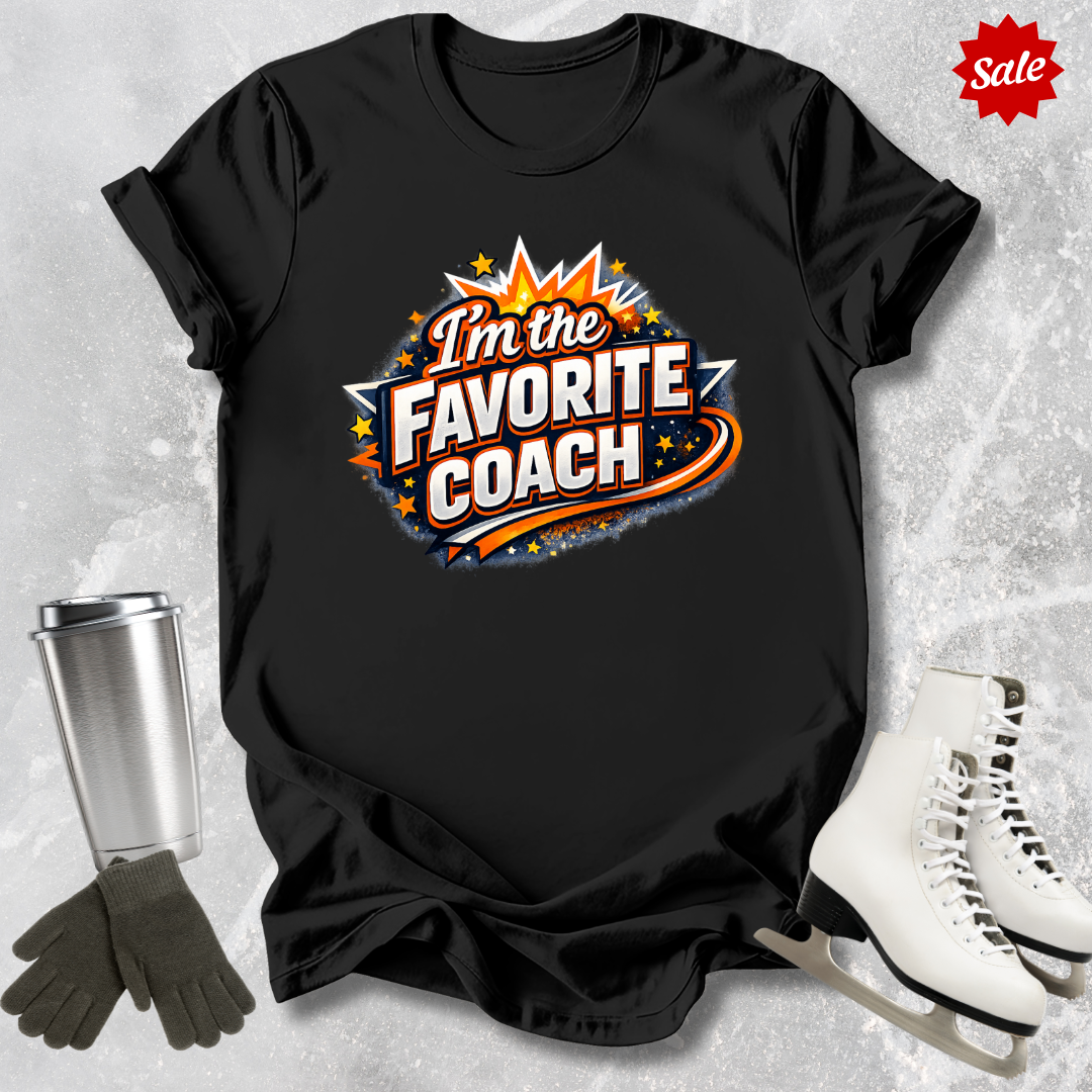 Black t-shirt with 'I'm the Favorite Coach' design  for figure skating coaches on a textured gray background with ice skates and gloves.