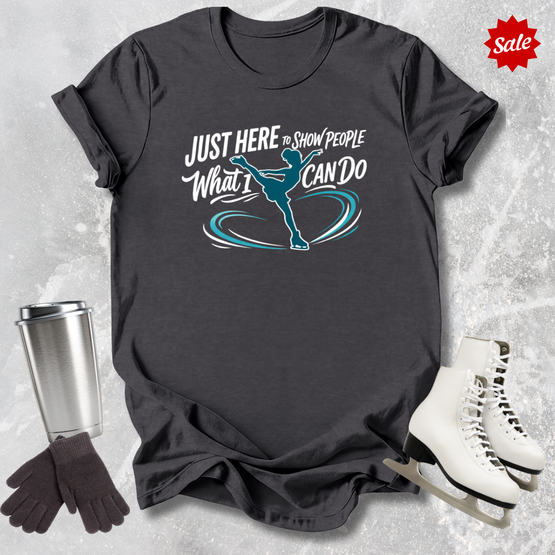 Black t-shirt with just here to show people what I can do figure skating graphic design and text, placed on a textured surface with a 'Sale' label.