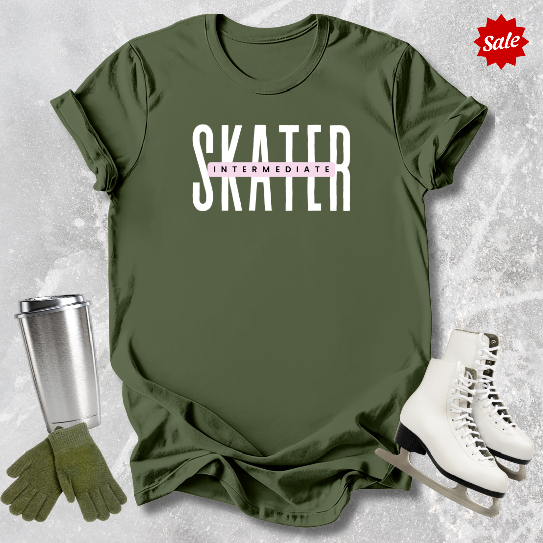 Green t-shirt with 'SKATER INTERMEDIATE' text, silver tumbler, green gloves, and white skates on a textured gray background.
