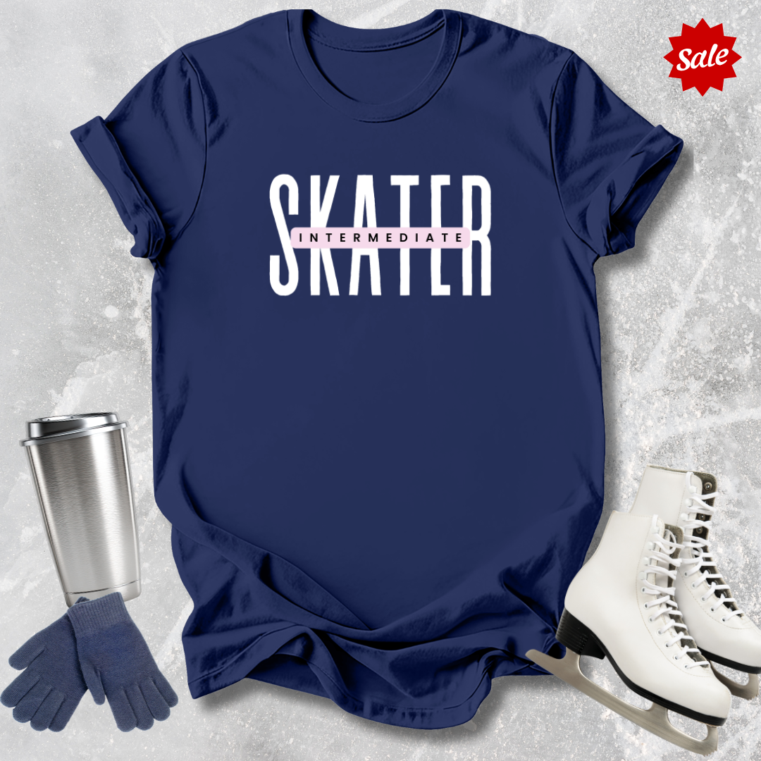 Black t-shirt with 'SKATER INTERMEDIATE' text, silver tumbler, black gloves, and white skates on a textured gray background.