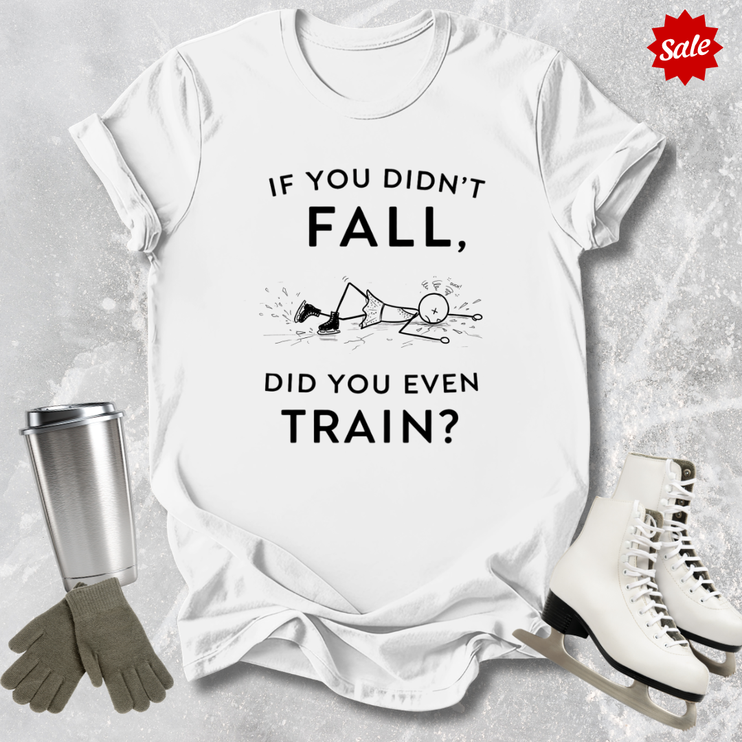 White t-shirt with humorous  if you didn't fall did you even train text, silver tumbler, gray gloves, and white ice skates on a textured surface.