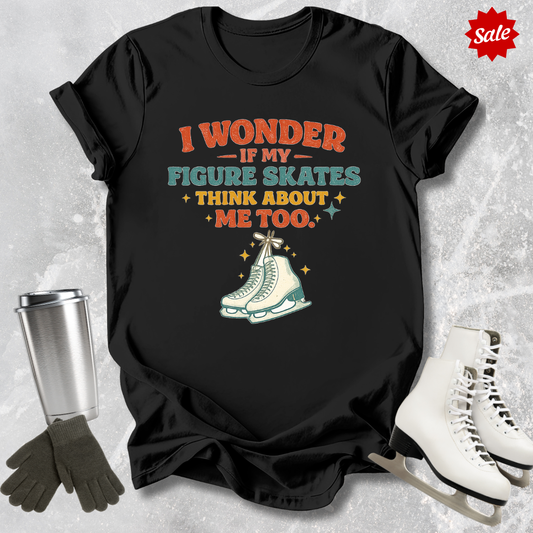 Black t-shirt with figure skating graphic and text on a textured gray background