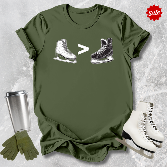 Green t-shirt with  a funny figure skating is greater than hockey graphic, silver tumbler, blue gloves, and white ice skates on a textured gray background.