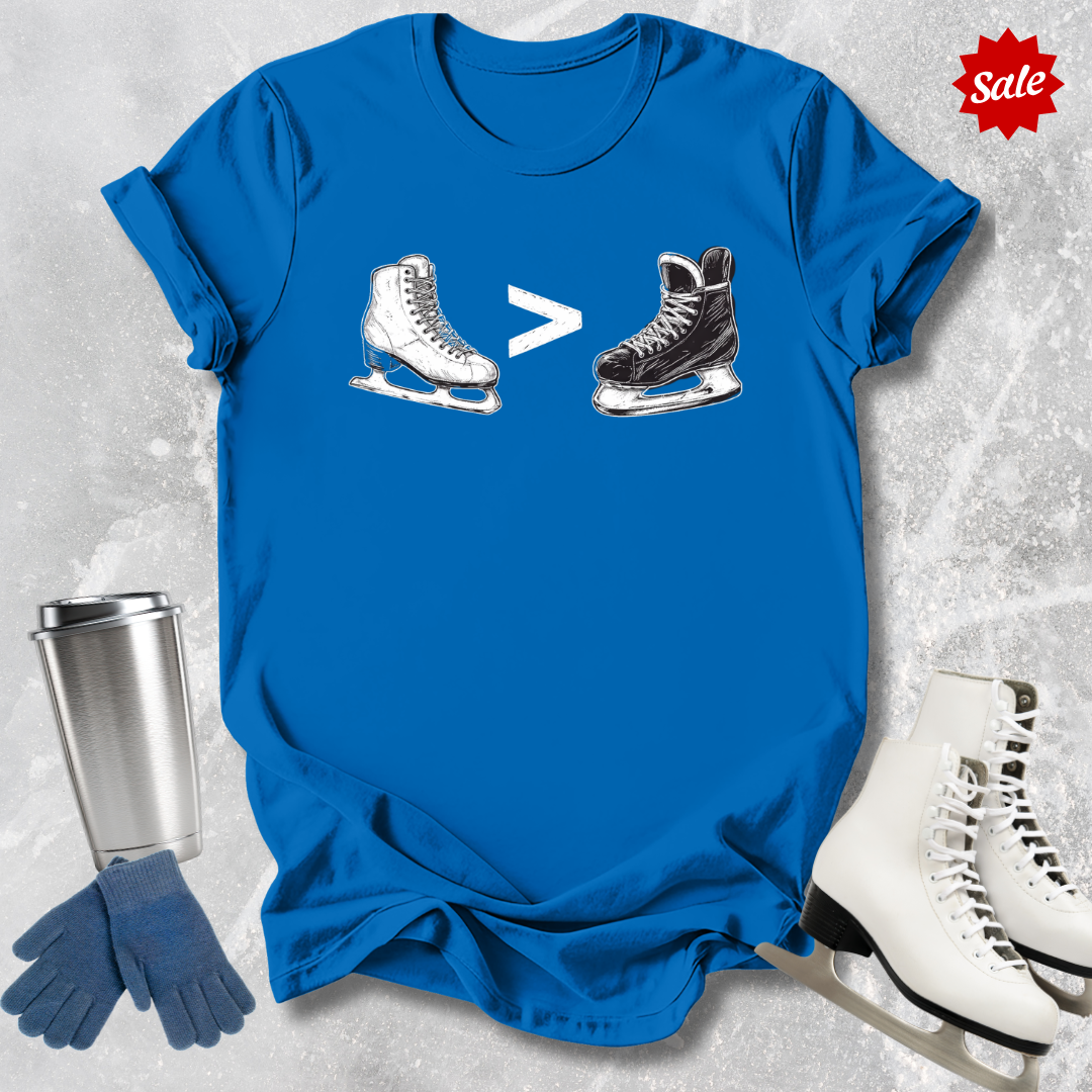 Blue t-shirt with  a funny figure skating is greater than hockey graphic, silver tumbler, blue gloves, and white ice skates on a textured gray background.