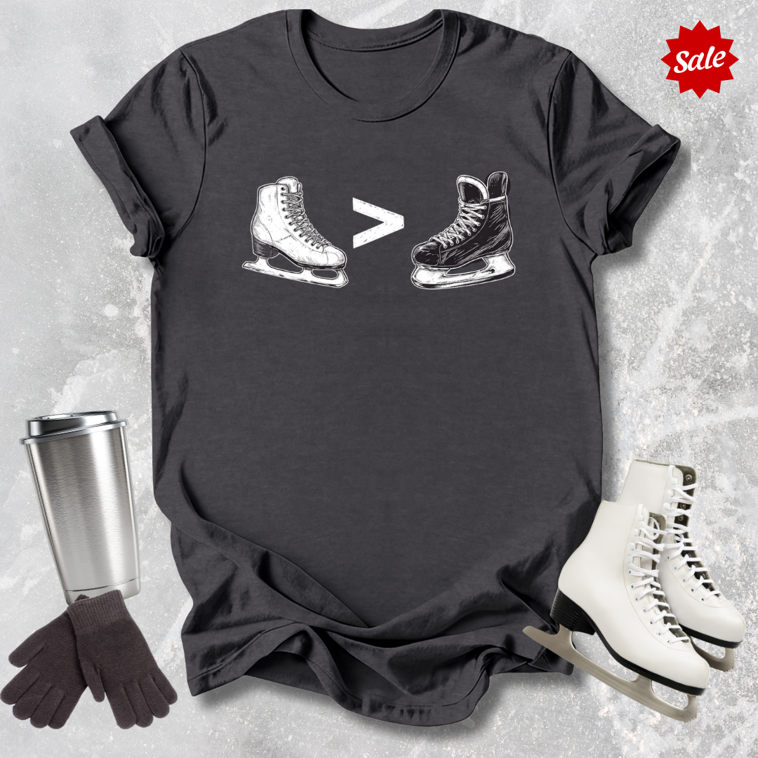 Black t-shirt with  a funny figure skating is greater than hockey graphic, silver tumbler, blue gloves, and white ice skates on a textured gray background.