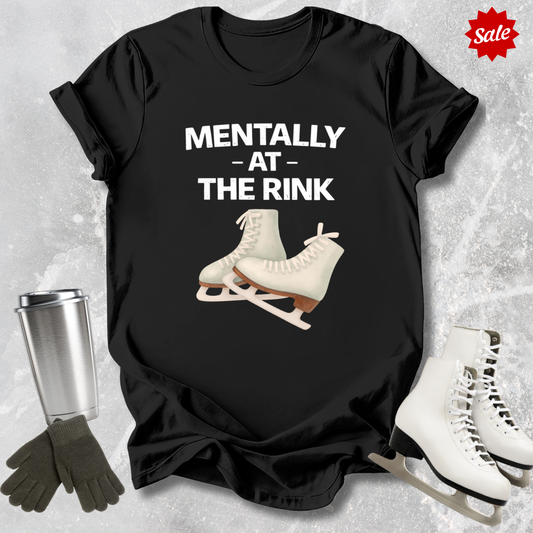 Black t-shirt with ice skates and text 'Mentally at the Rink' on a textured gray background.