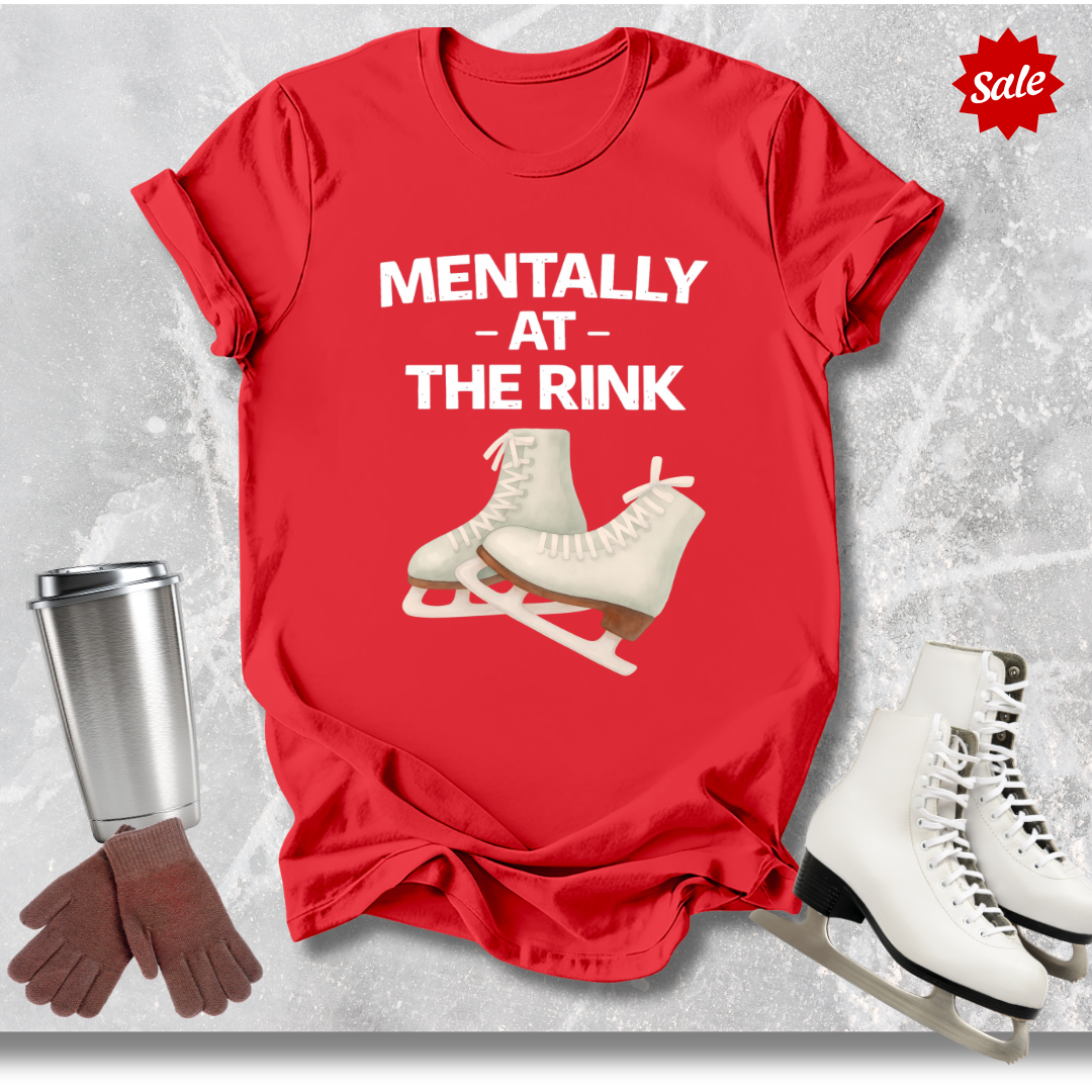 Red t-shirt with ice skate design and text, surrounded by ice skates, gloves, and a cup on a textured gray background.