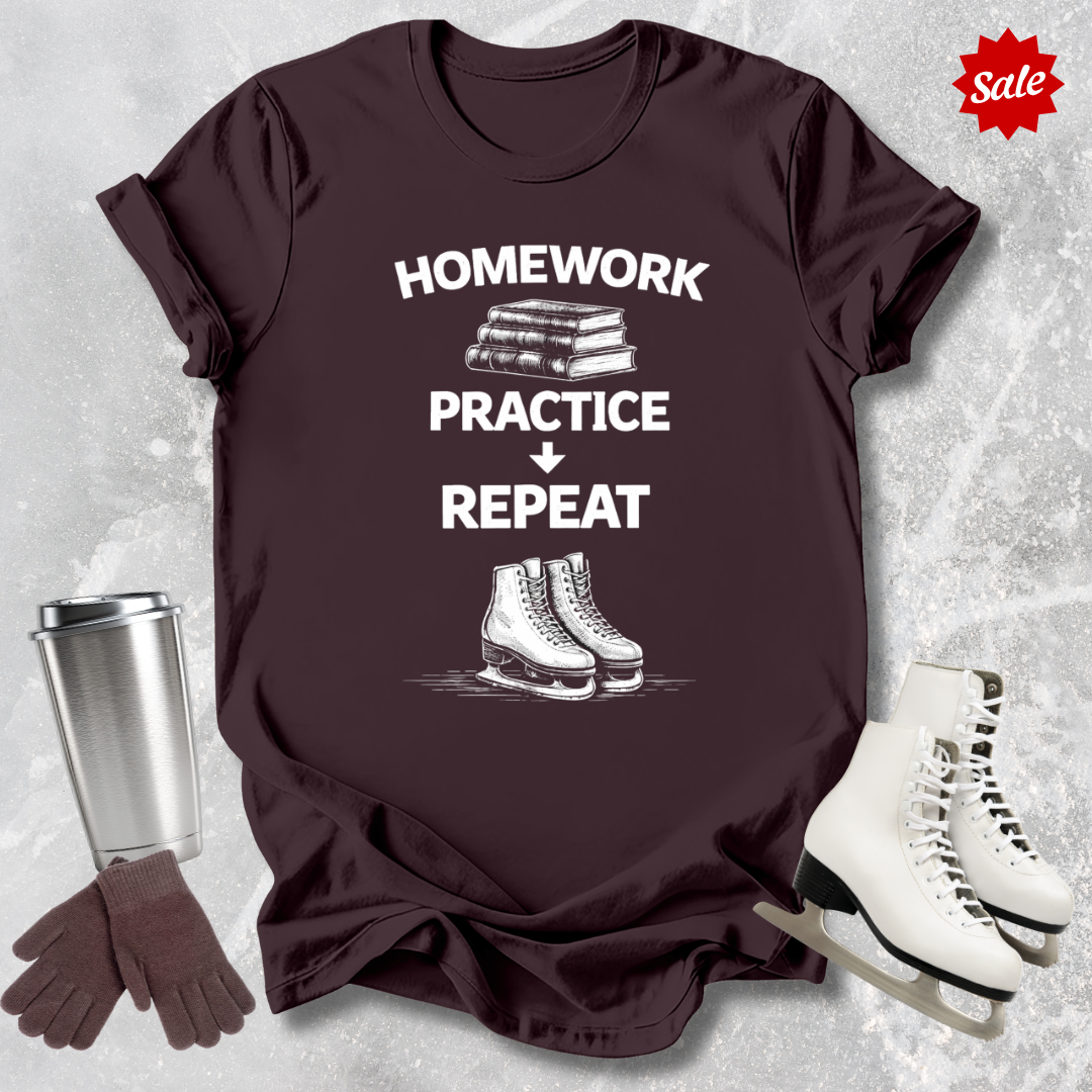 Brown t-shirt with 'Homework, practice, repeat' text, next to a silver tumbler, black gloves, and white figure skates on a textured gray background.