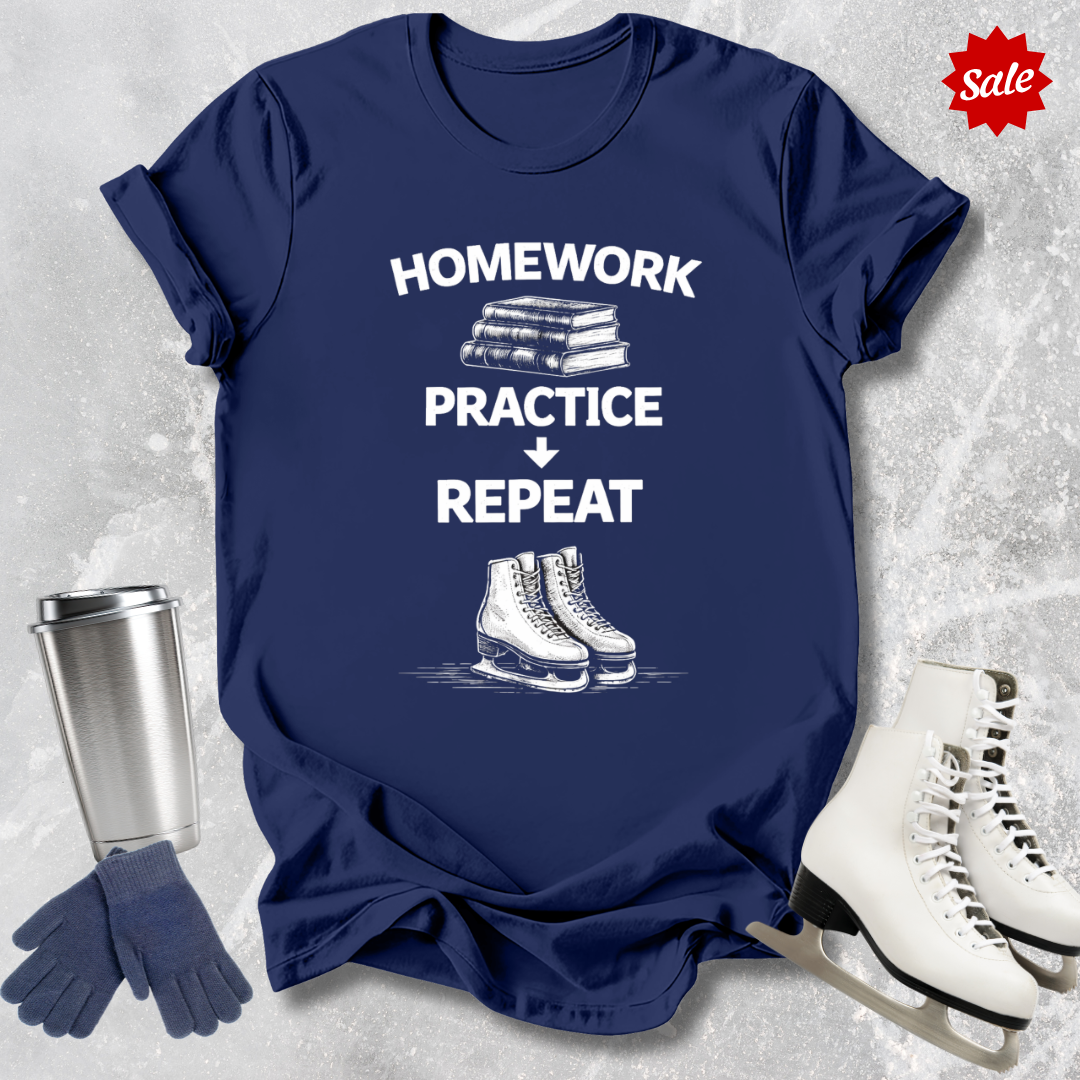 Navy t-shirt with 'Homework, practice, repeat' text, next to a silver tumbler, black gloves, and white figure skates on a textured gray background.