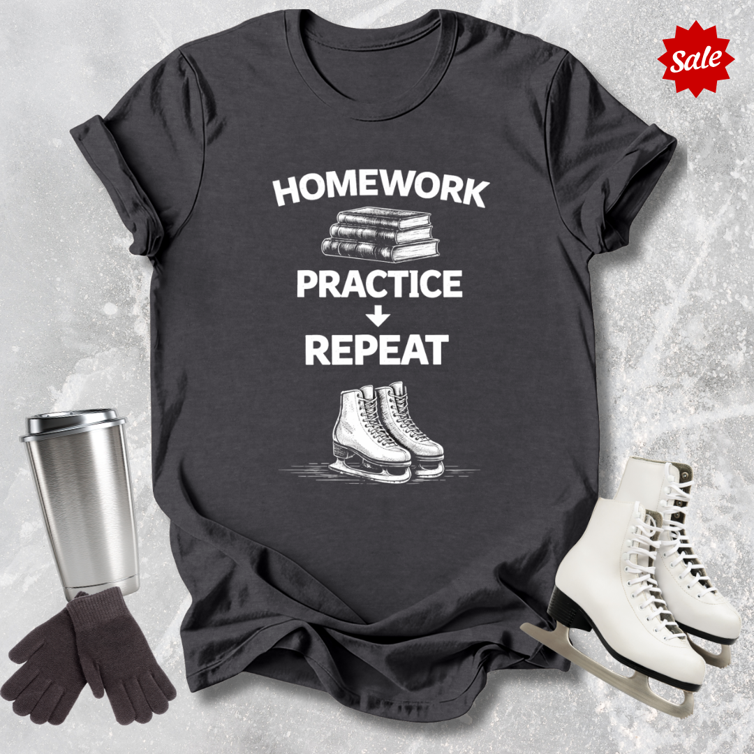 Gray t-shirt with 'Homework, practice, repeat' text, next to a silver tumbler, black gloves, and white figure skates on a textured gray background.