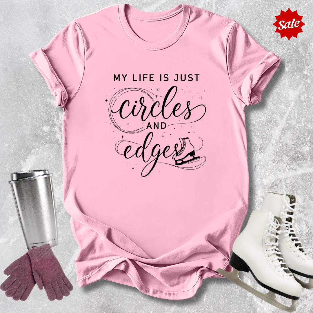 Pink t-shirt with My Life is just circles and edges Figure Skating text, silver tumbler, pink gloves, and white skates on a light gray background