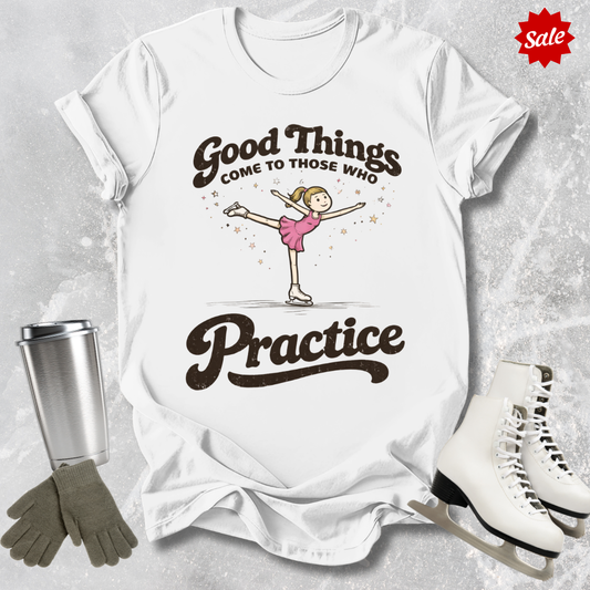 White t-shirt with a graphic and text, surrounded by ice skates, gloves, and a tumbler on a textured surface.