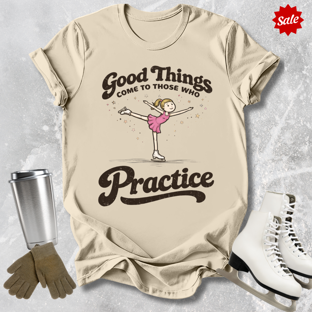 Beige t-shirt with a graphic of a girl on skates and text, placed on a textured surface with a tumbler, gloves, and skates.