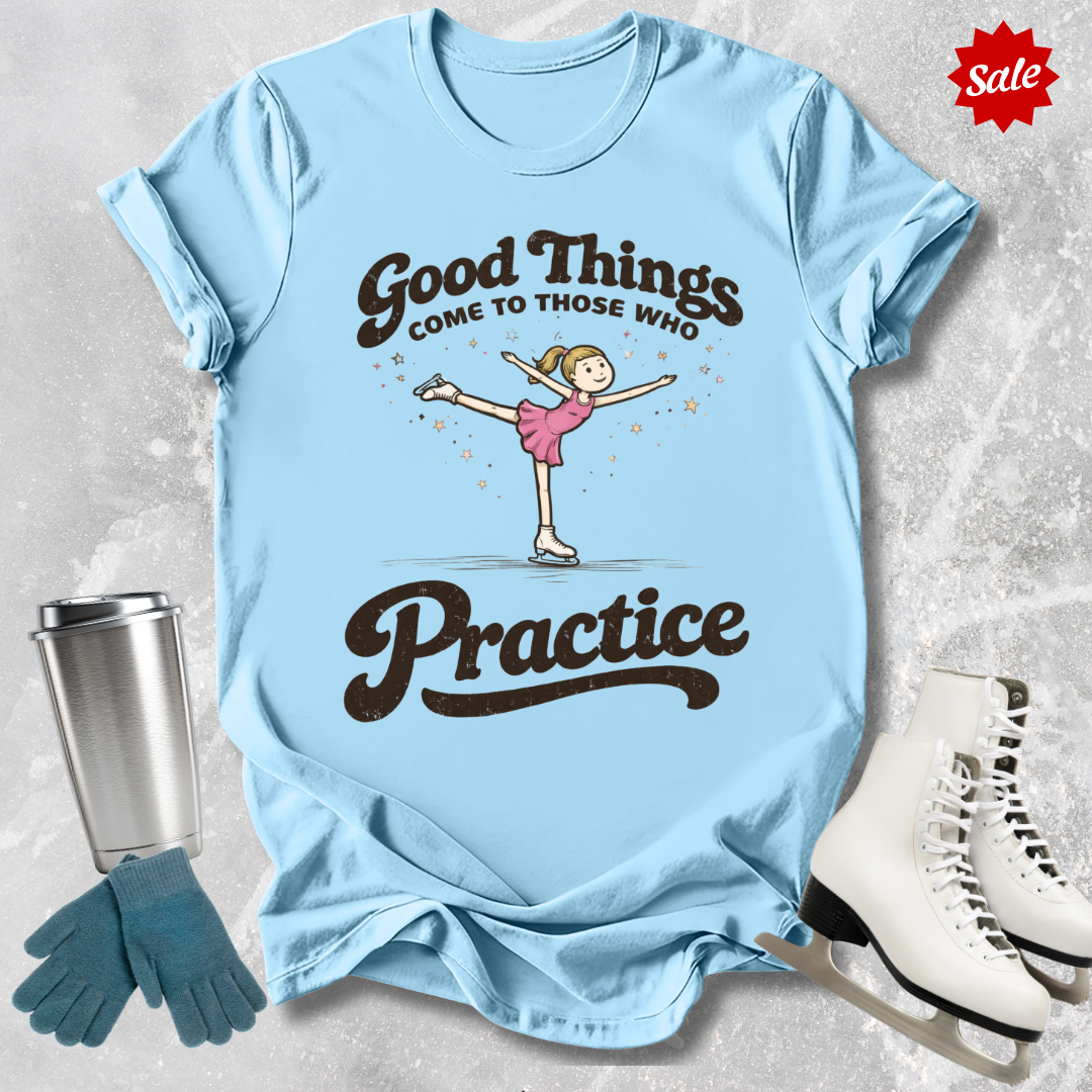 Light blue t-shirt with a graphic and text, placed on a textured surface with accessories like gloves and skates.