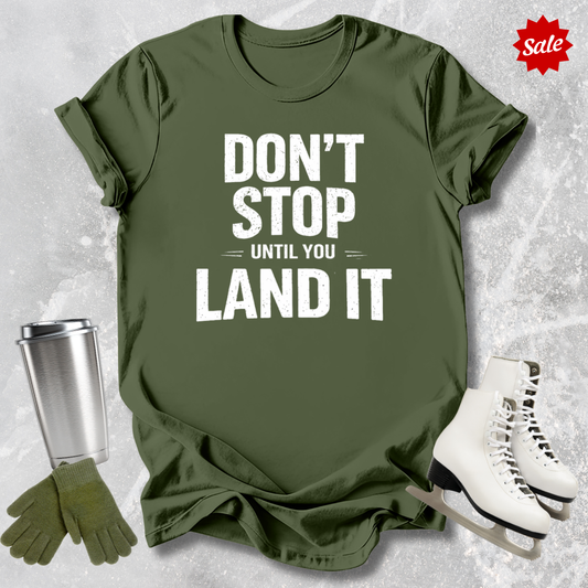 Green t-shirt with motivational quote, silver tumbler, green gloves, and white skates on a textured gray background.