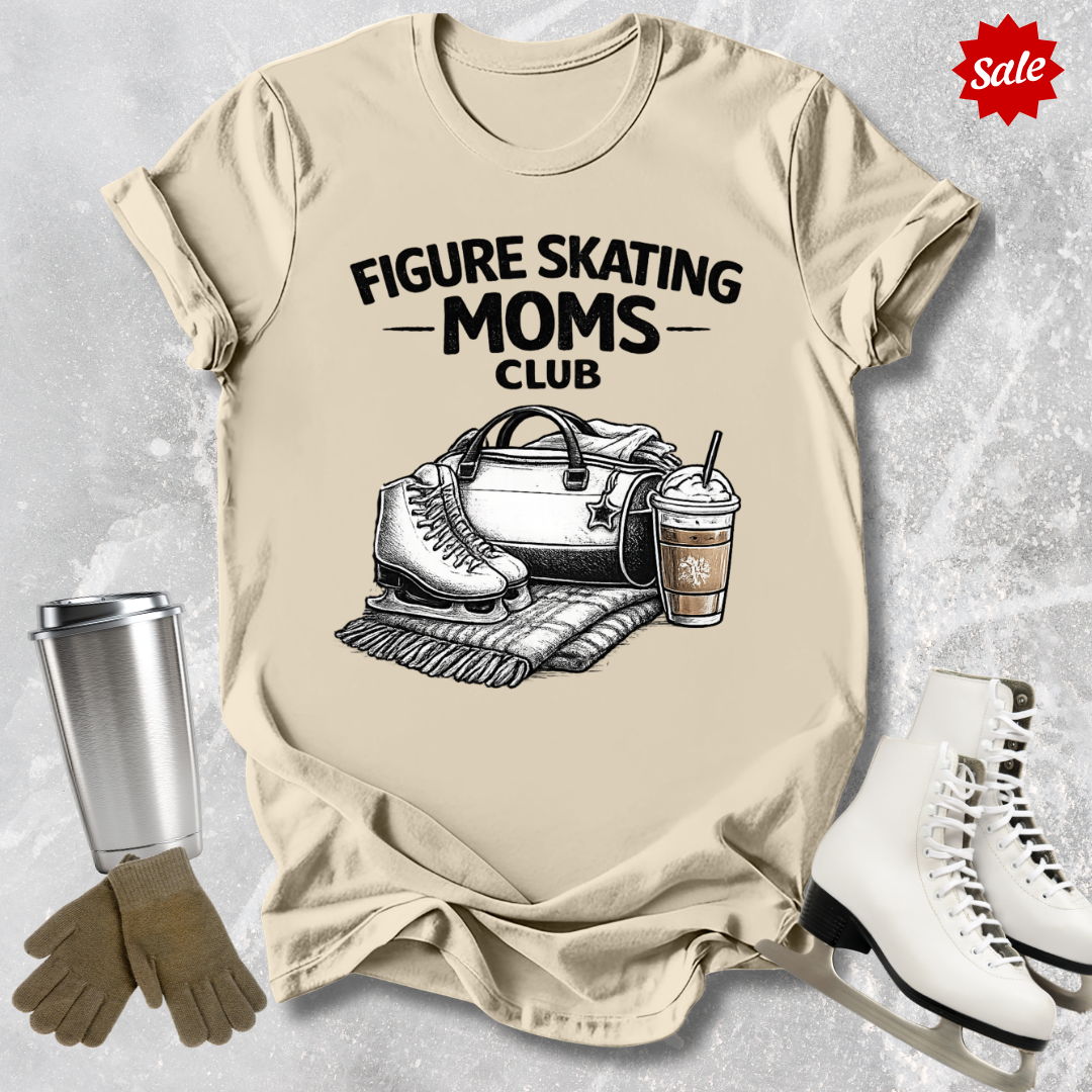 Beige t-shirt with 'Figure Skating Moms Club' graphic, surrounded by ice skates, gloves, and a cup on a textured surface.