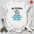 White t-shirt with ice skating graphic and text, surrounded by ice skates and a tumbler on a textured surface.