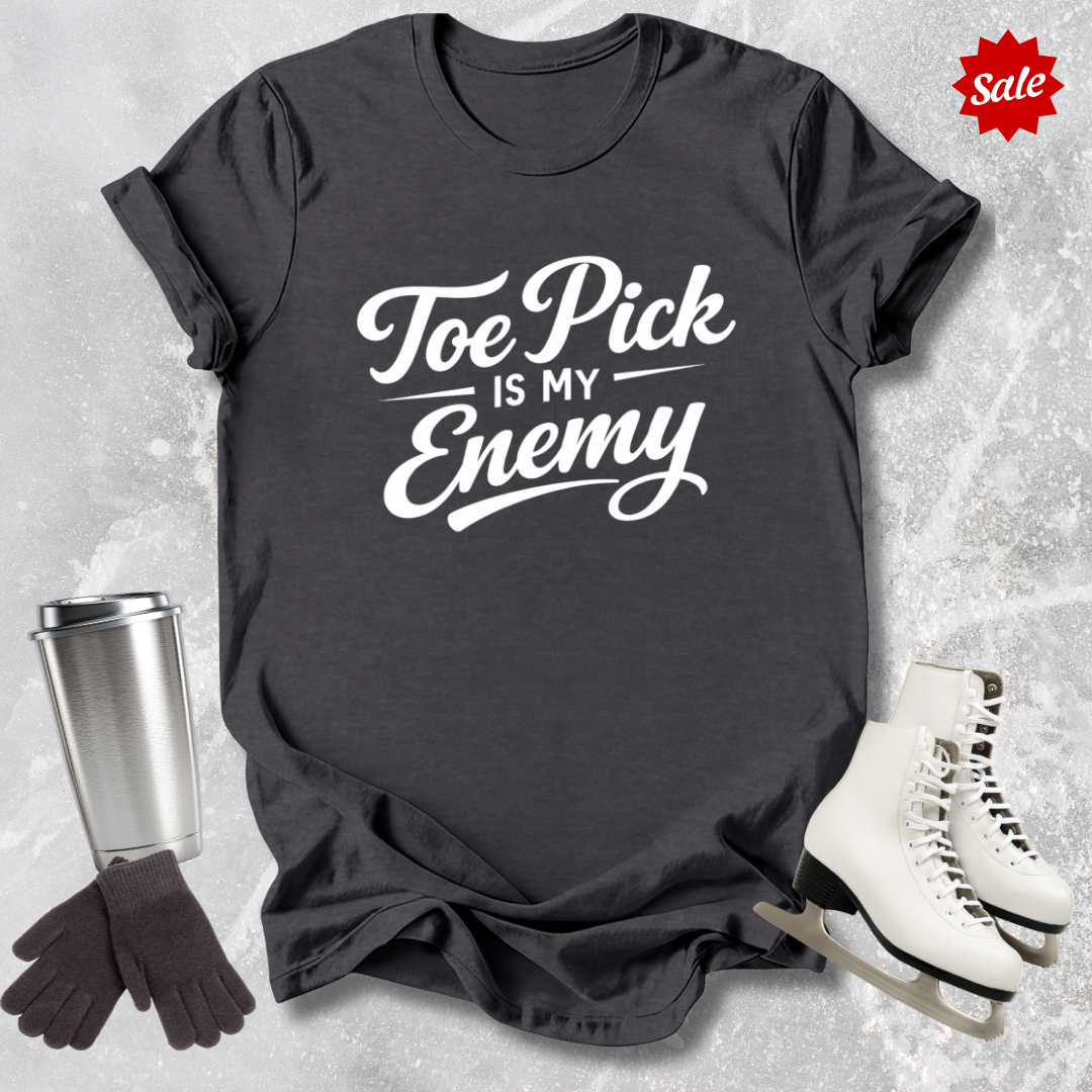 Black t-shirt with 'Toe Pick is My Enemy' text, surrounded by winter accessories on a textured surface.