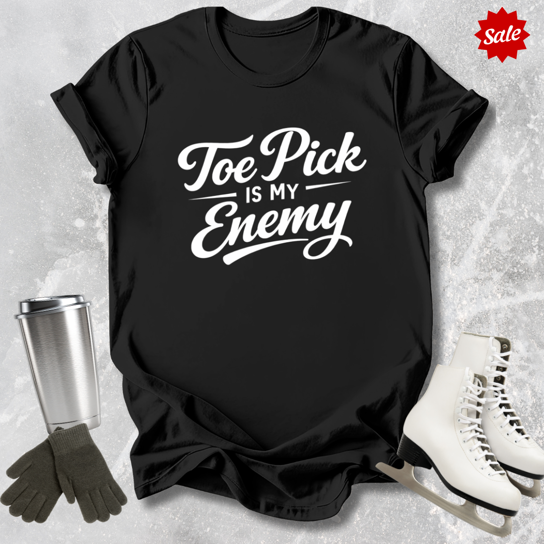 Black t-shirt with ice skating design and text, surrounded by ice skates and a tumbler on a textured gray background.
