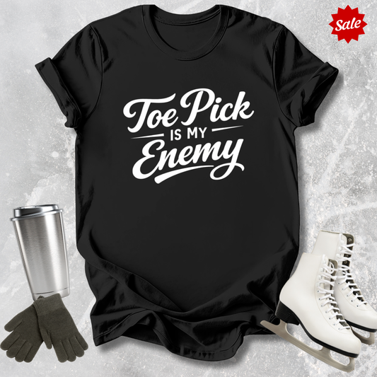 Black t-shirt with ice skating design and text, surrounded by ice skates and a tumbler on a textured gray background.
