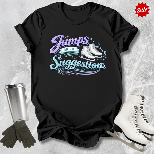 Black t-shirt with 'Jumps are a Suggestion' text, silver tumbler, black gloves, and white ice skates on a textured gray background.