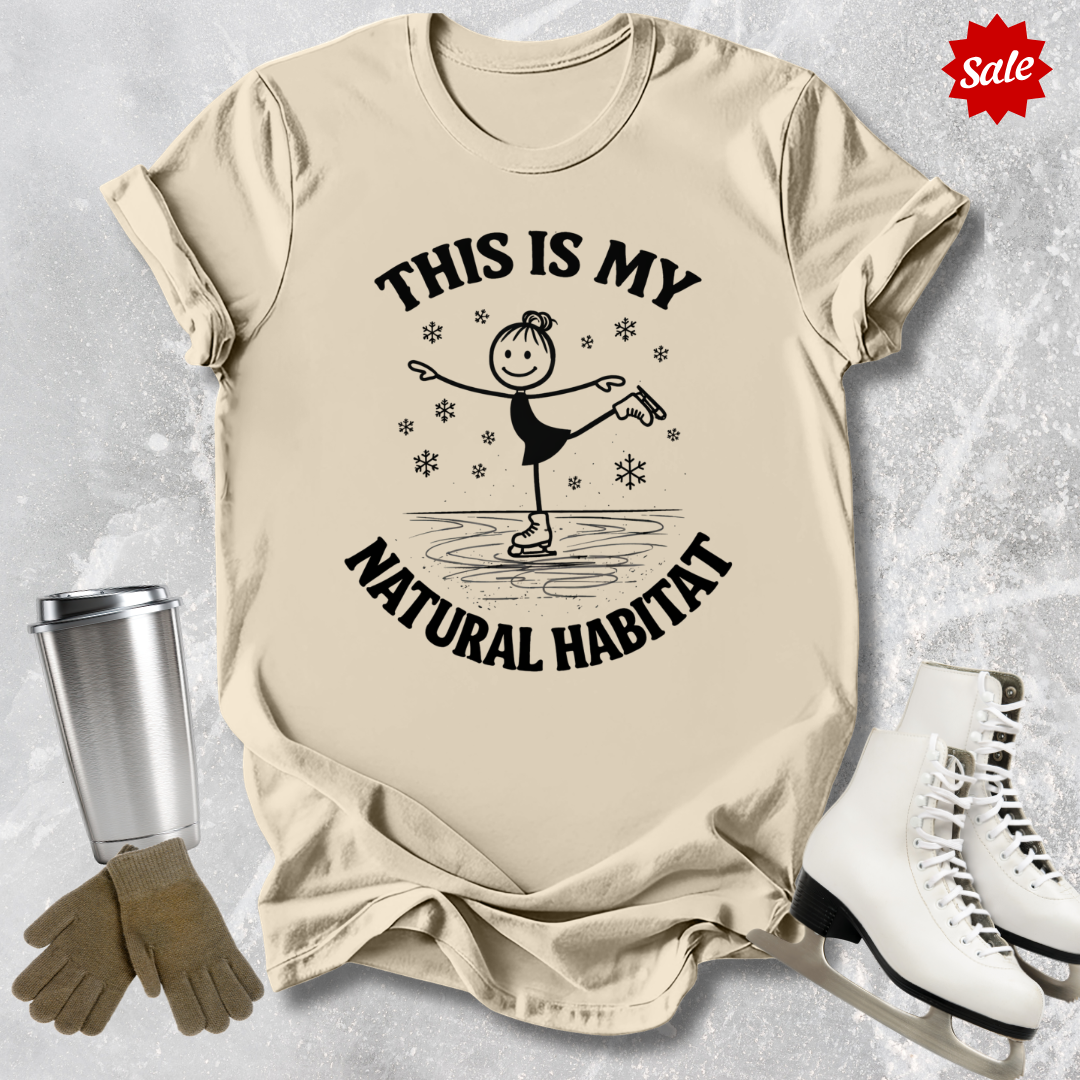 Beige t-shirt with graphic this is my natural habitat skater design and ice skates on a textured surface