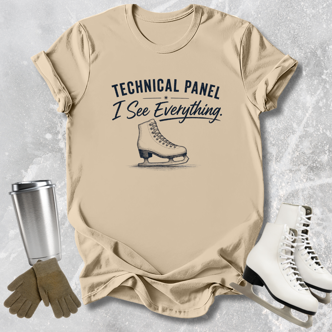 Beige t-shirt with ice skate graphic and text, surrounded by ice skates and gloves on a textured surface.