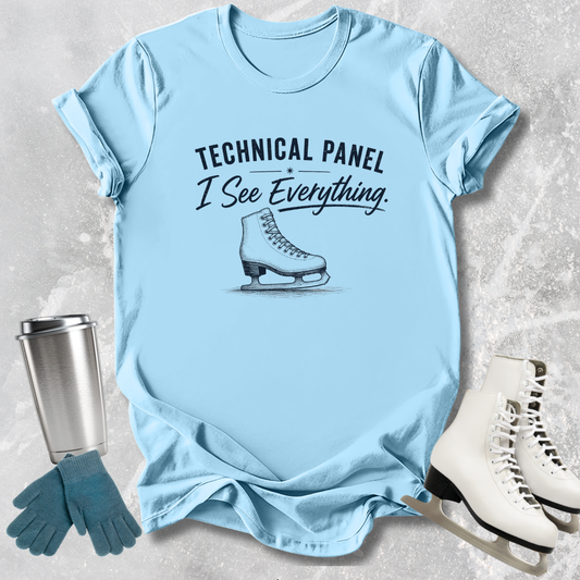 Light blue t-shirt with text and graphic, next to ice skates and gloves on a textured surface