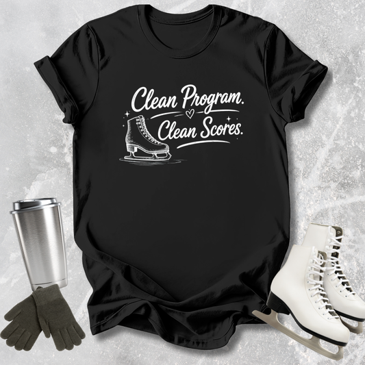 Black t-shirt with 'Clean Program, Clean Scores' text and ice skate graphic on a textured surface with ice skates and gloves.
