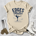 Beige t-shirt with 'Edges Matter' graphic and ice skates on a textured surface