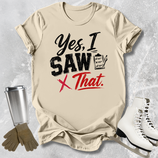 Beige t-shirt with humorous text design, placed on a textured surface with accessories like a tumbler, gloves, and skates.