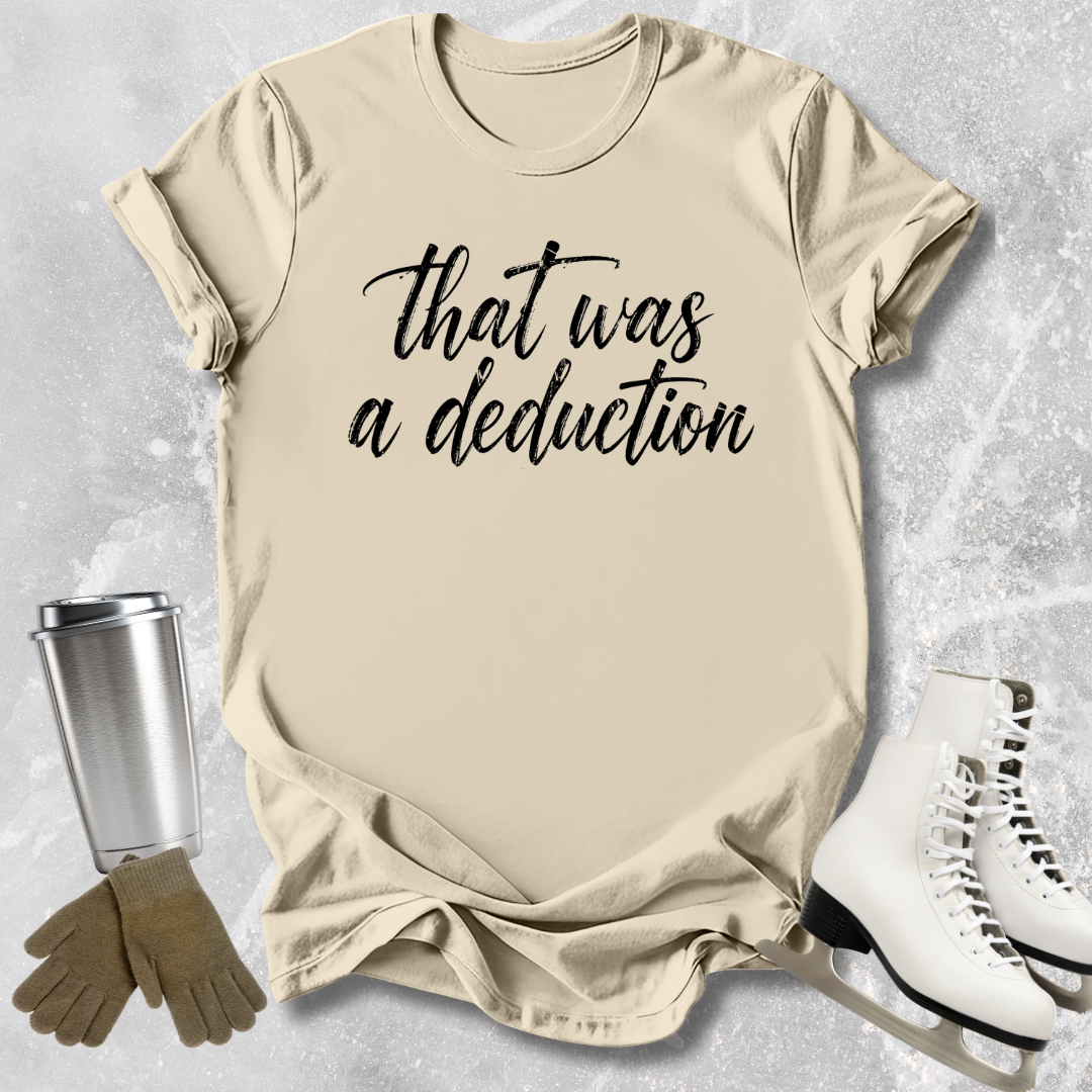 Beige t-shirt with 'That was a deduction' text, next to a silver tumbler, brown gloves, and white skates on a light gray background.