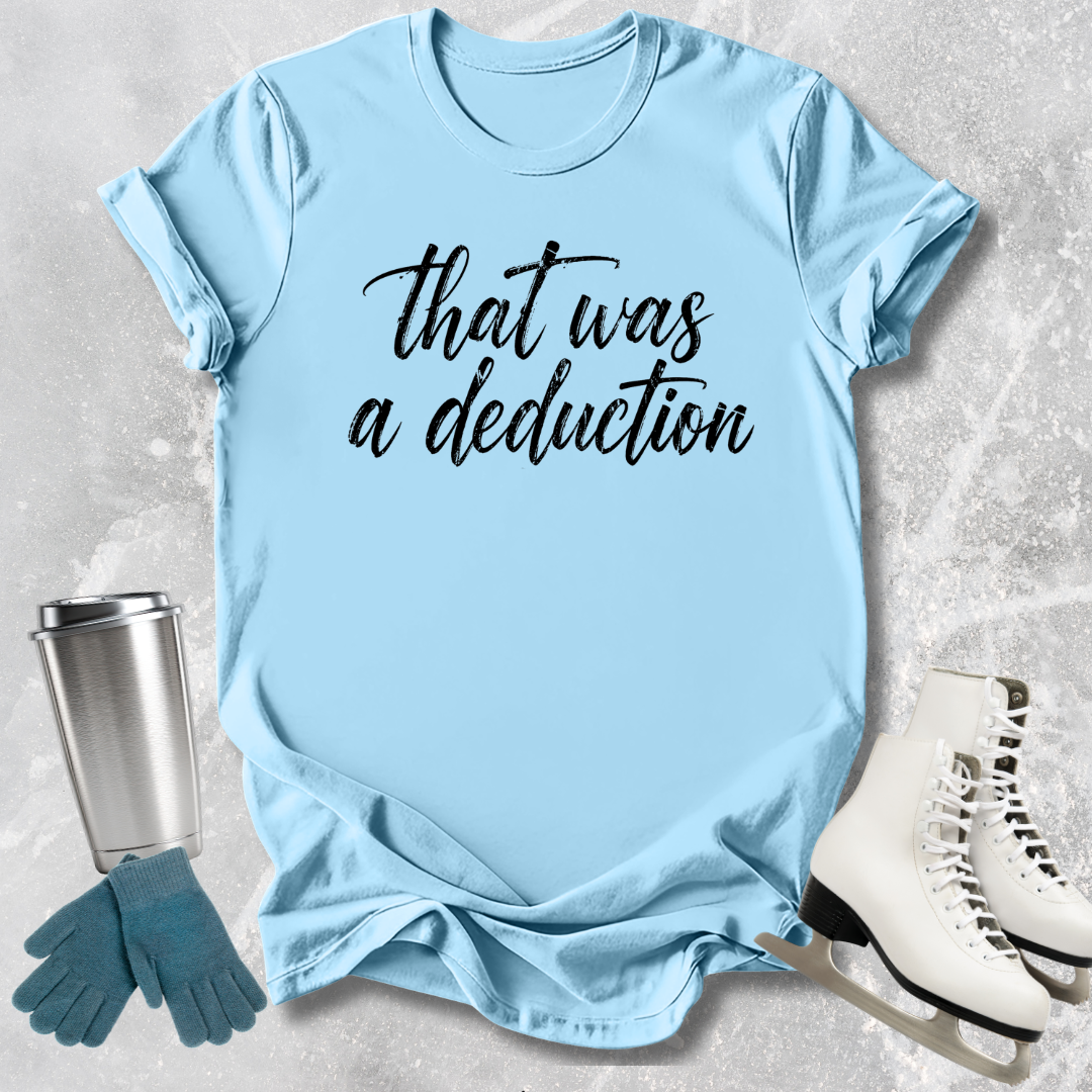 Light blue t-shirt with 'That was a deduction' text, next to a silver tumbler, green gloves, and white skates on a textured surface.