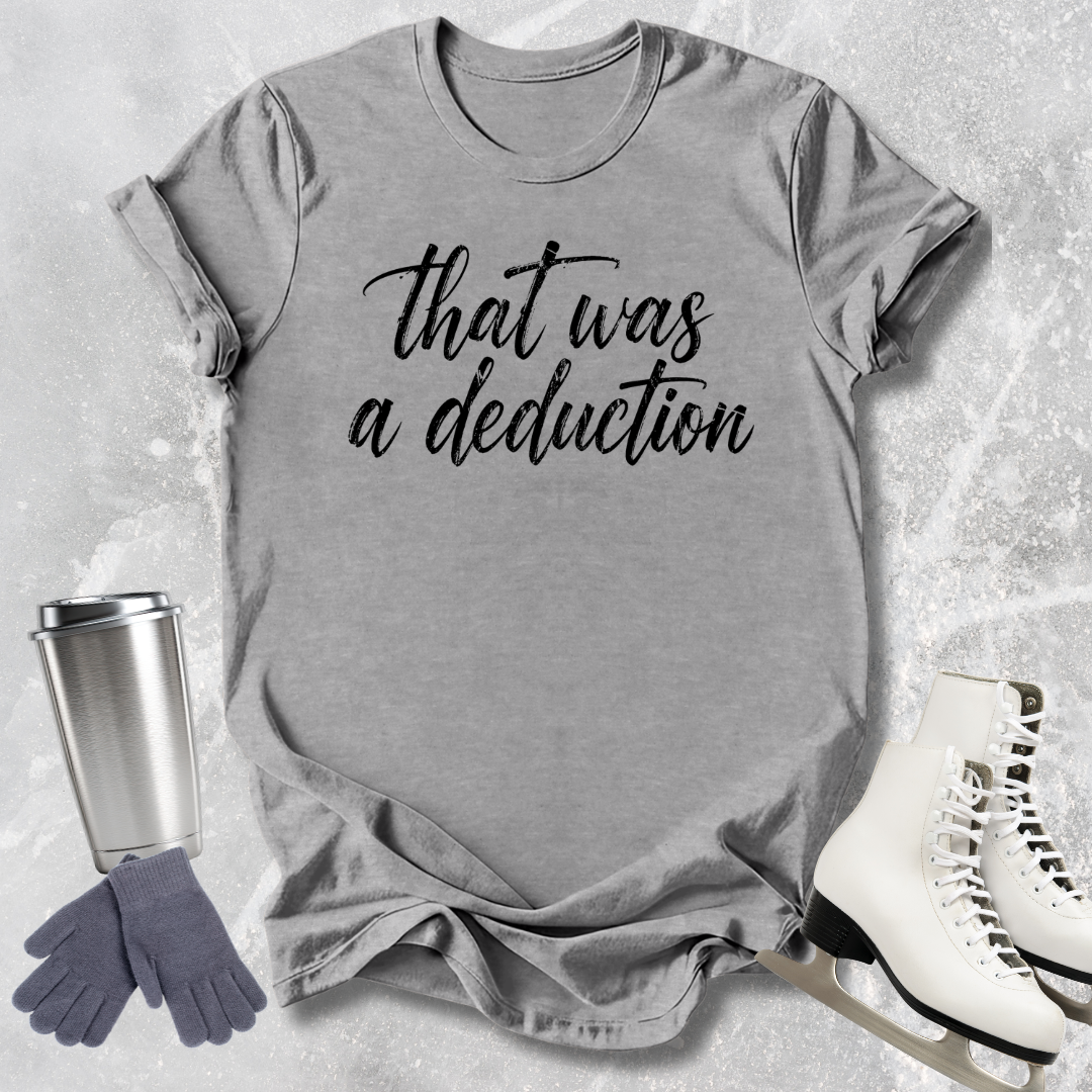 Gray t-shirt with 'That was a deduction' text, next to a silver tumbler, gray gloves, and white skates on a textured surface.