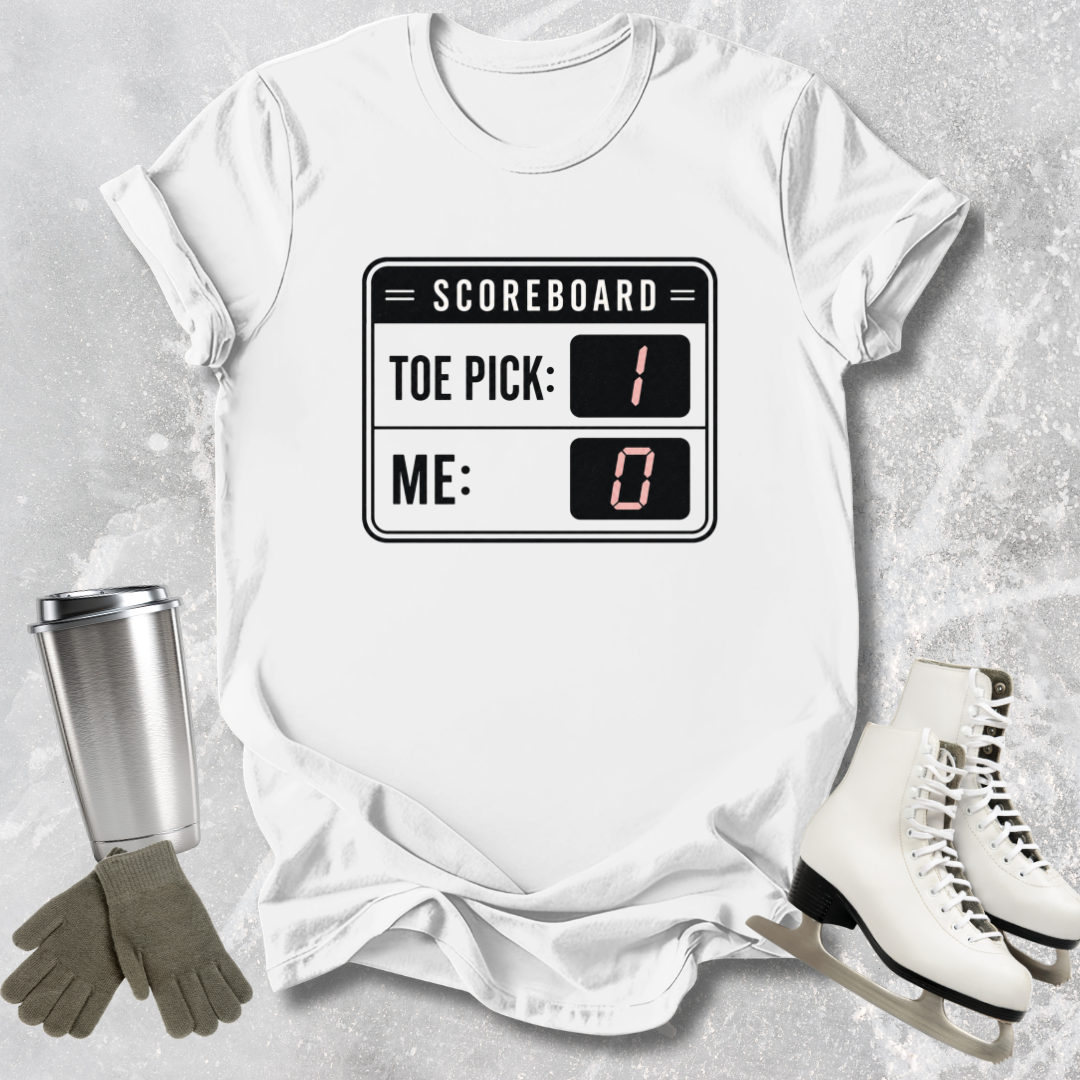 White t-shirt with scoreboard design, surrounded by ice skates, gloves, and a tumbler on a textured surface.