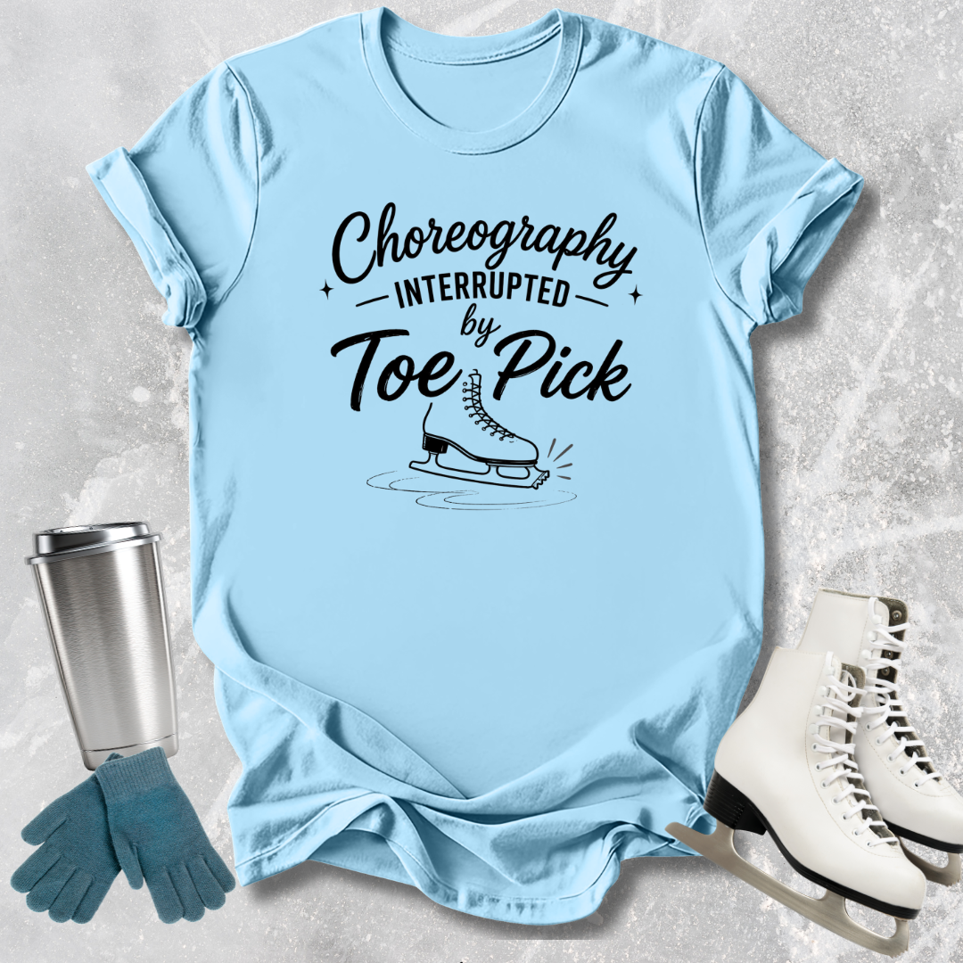 Light blue t-shirt with humorous graphic and text, placed on a textured surface with ice skates and gloves.