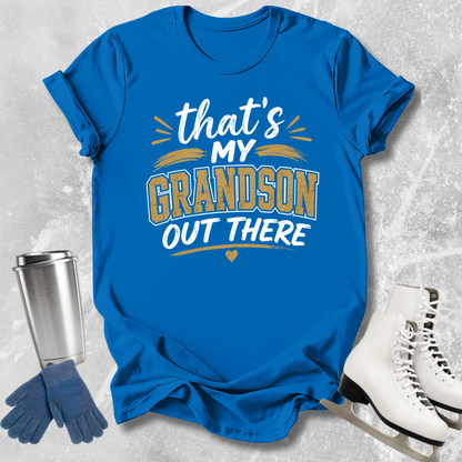 Blue t-shirt with 'That's my grandson out there' text, next to a silver tumbler, blue gloves, and white skates on a textured gray background.
