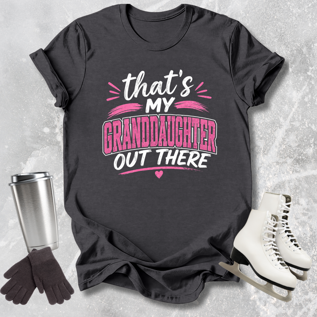 Black t-shirt with 'That's my granddaughter out there' text, next to a silver tumbler, black gloves, and white skates on a textured gray background.